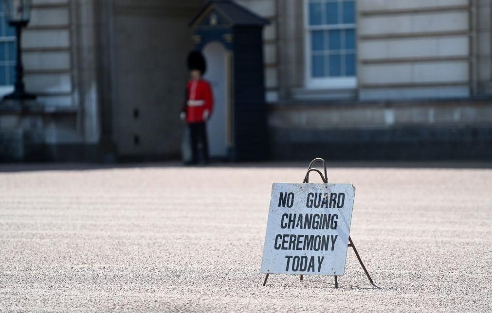 Silêncio e lágrimas da multidão e bandeira a meia haste em Buckingham